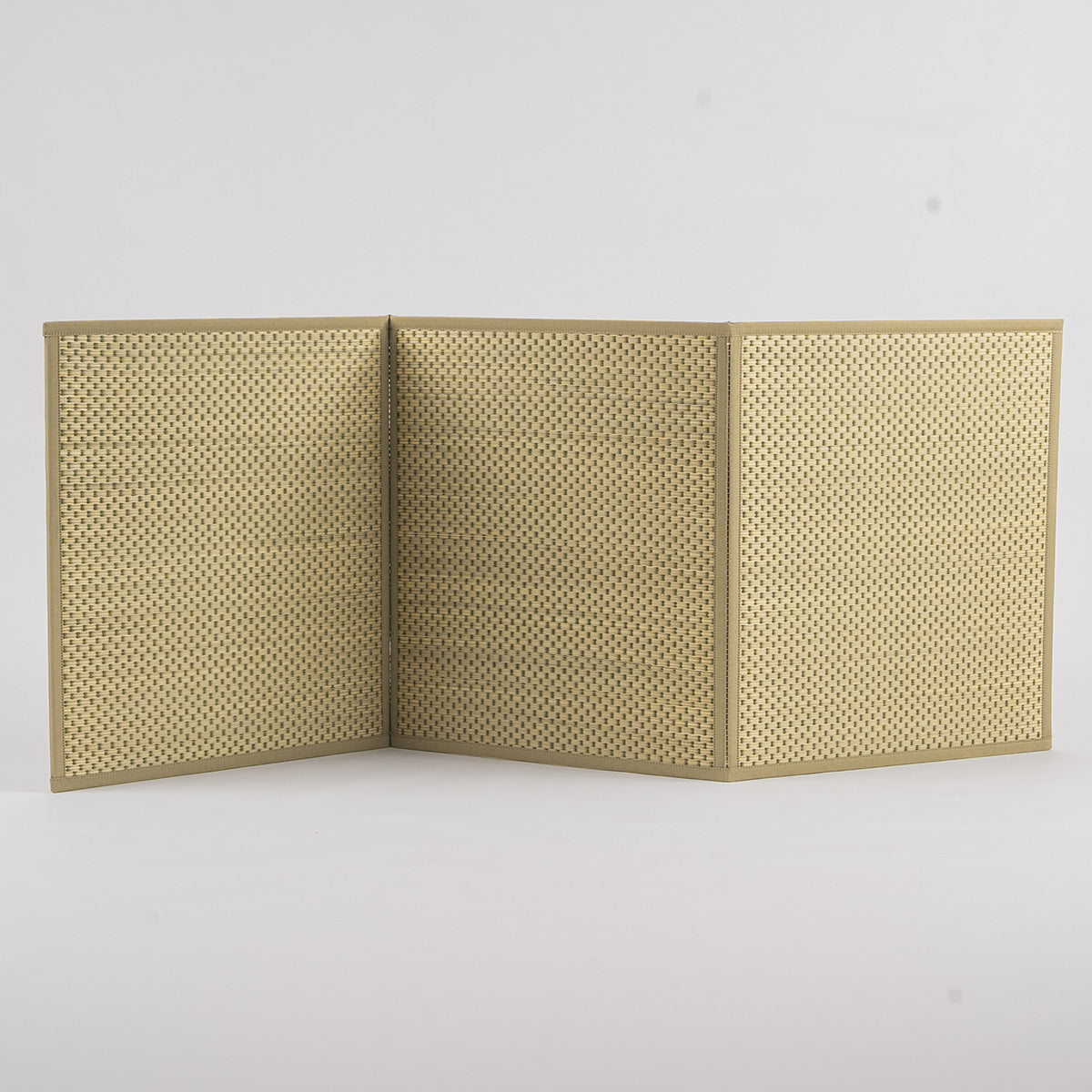 A folded three-fold green igusa tatami mat on a wood floor.
