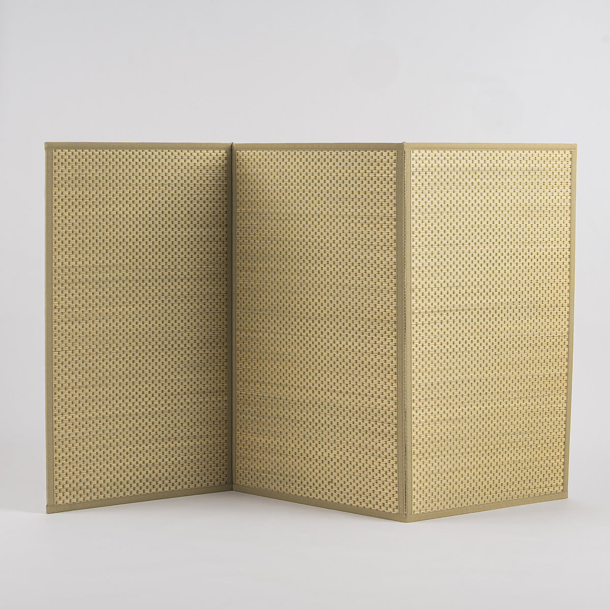 A folded three-fold green igusa tatami mat on a wood floor.