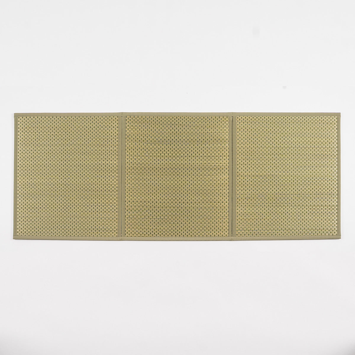 A folded three-fold green igusa tatami mat on a wood floor.