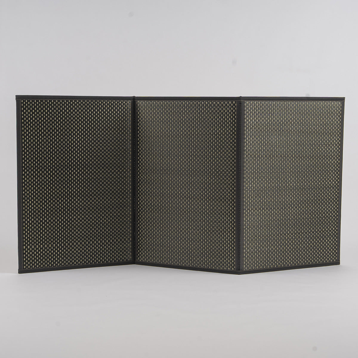 A folded three-fold black igusa tatami mat on a wood floor.
